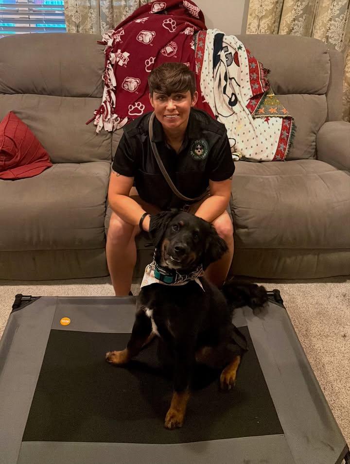 Ginger sitting on a raised training bed with her trainer